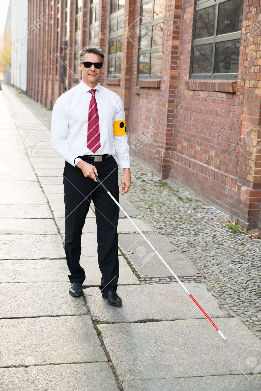 35462488-Blind-Man-Walking-On-Sidewalk-Holding-Stick-Wearing-Armband-Stock-Photo.jpg