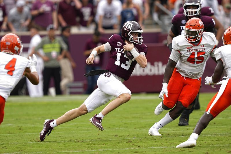 Texas A&M quarterback Haynes King (13) runs for a first down as Sam Houston State's Tyler Moore (45) defends the first half of an NCAA college football game Saturday, Sept. 3, 2022, in College Station, Texas. (AP Photo/David J. Phillip)